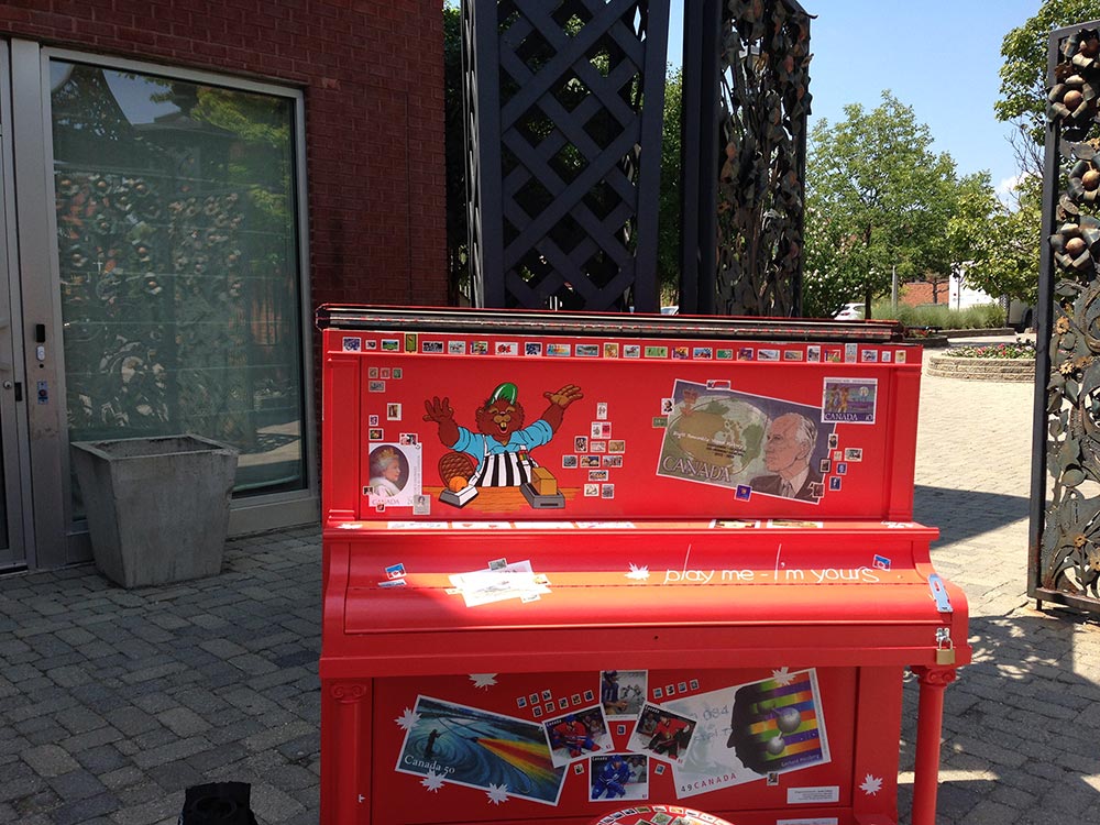 Red Piano with postage stamp images,